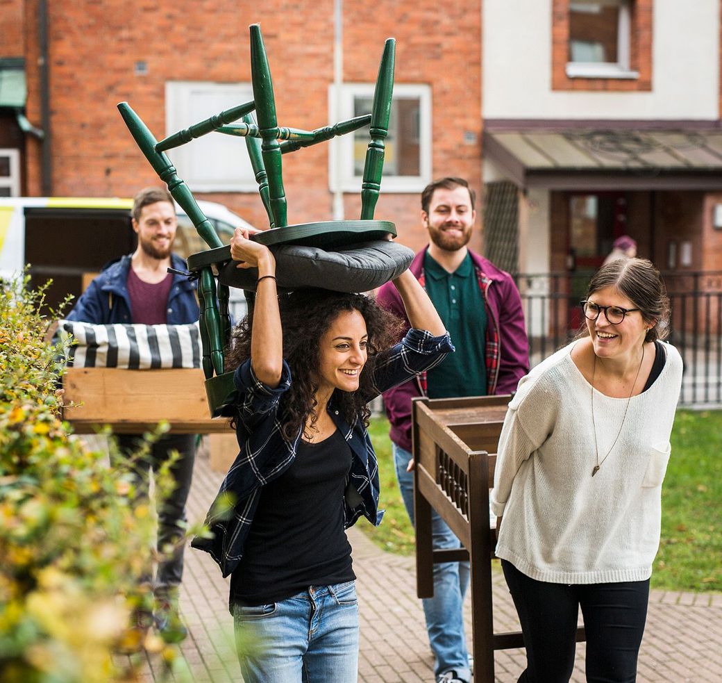 Friends moving furniture in preparation for pressure washing