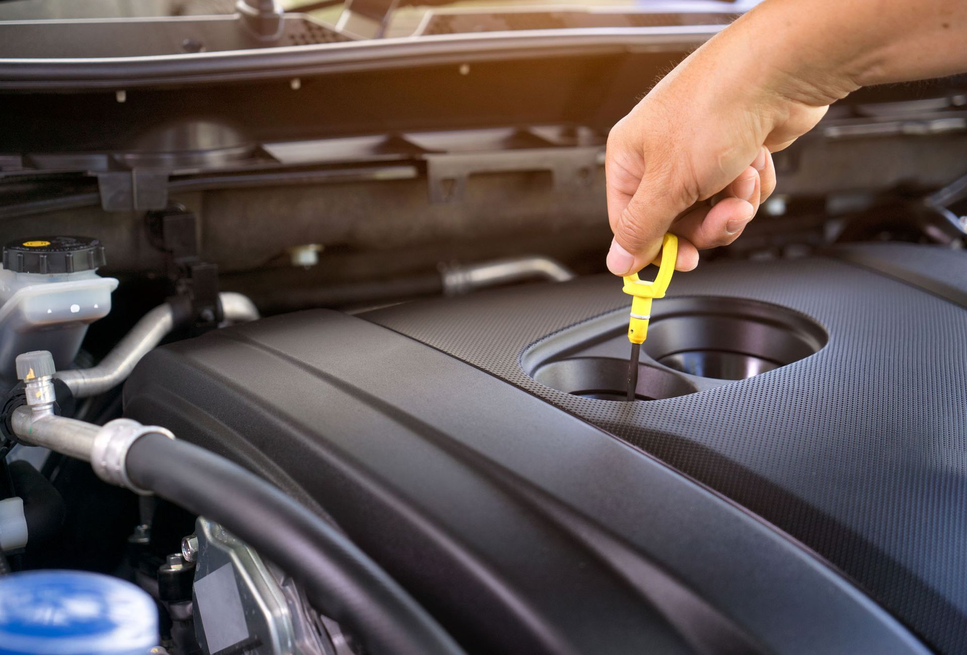 hand using dipstick to check engine oil level