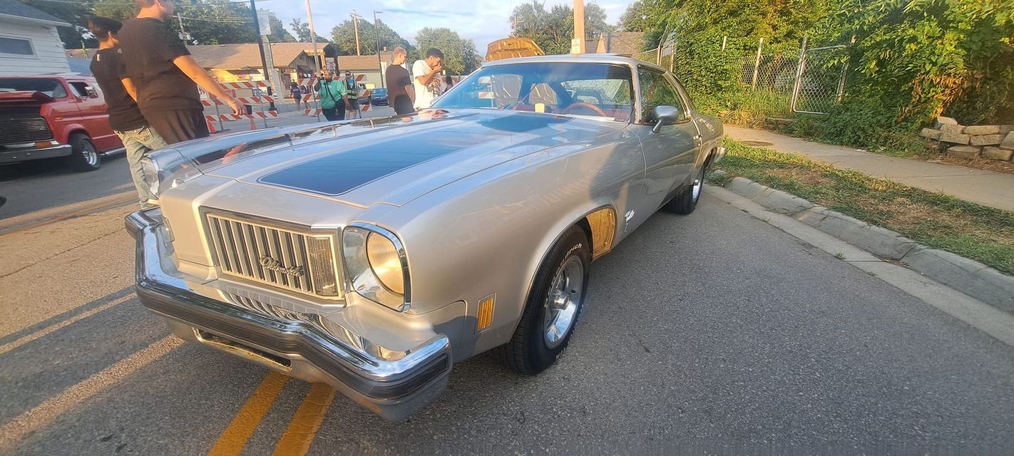A silver car is parked on the side of the road.