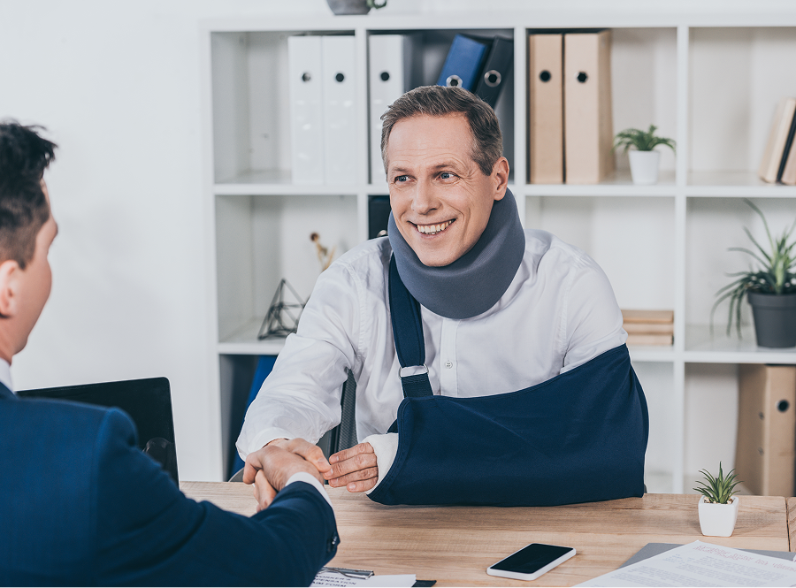 A man in a cast is shaking hands with a man in a suit.
