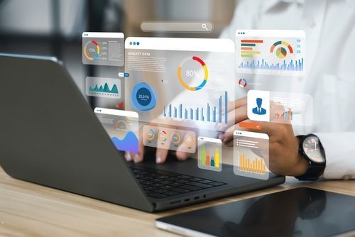 A person is pointing at a laptop screen with their finger