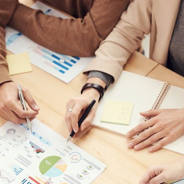 A group of people are sitting at a table looking at charts and graphs.