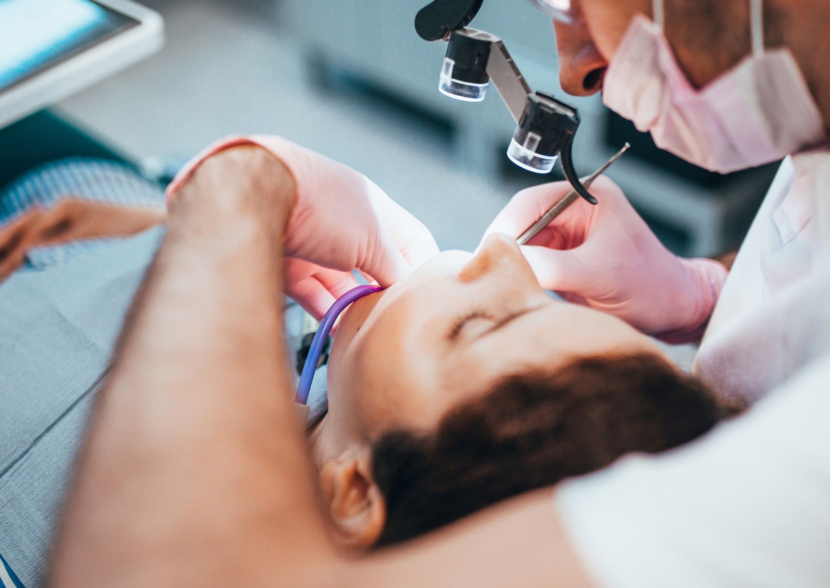 A woman is getting her teeth examined by a dentist.