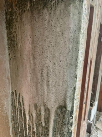 A close up of a concrete wall with a wooden frame.