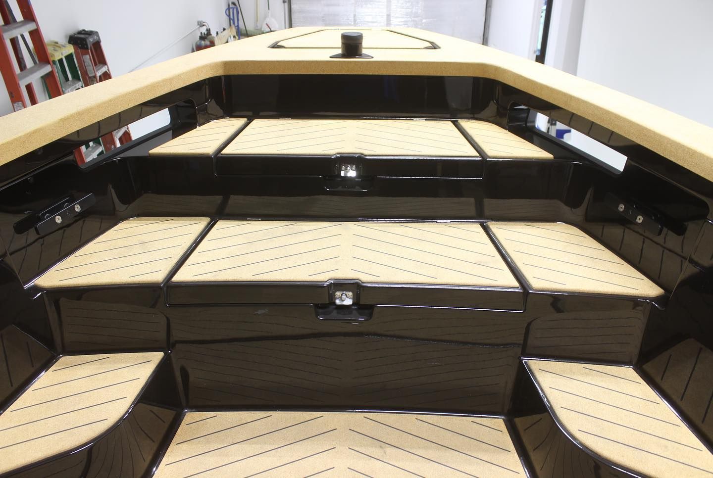 Wooden tiered seating with perforated tan pads in a theater or auditorium setting