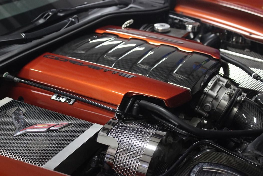 Close-up of a red and black car engine with chrome components in the engine bay