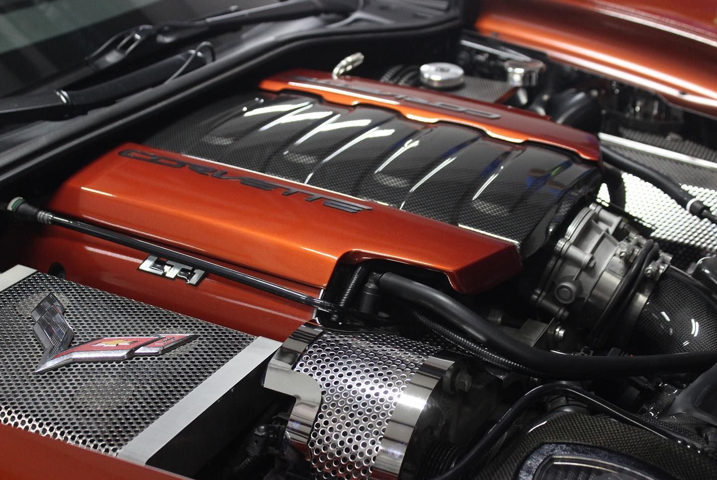 Close-up of a red and black car engine with chrome components in the engine bay
