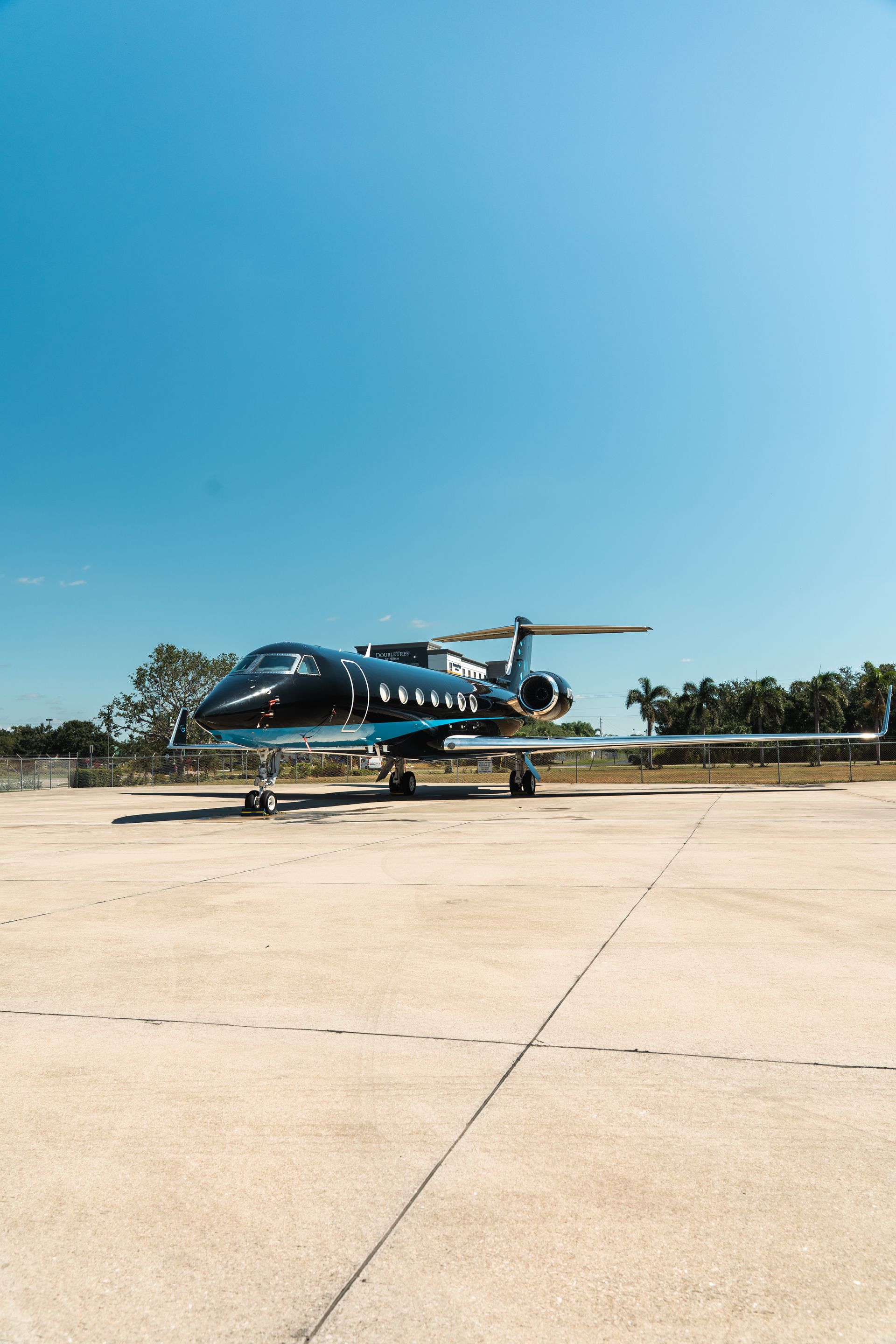 Blue and white jet parked on a sunny airport tarmac under a clear sky