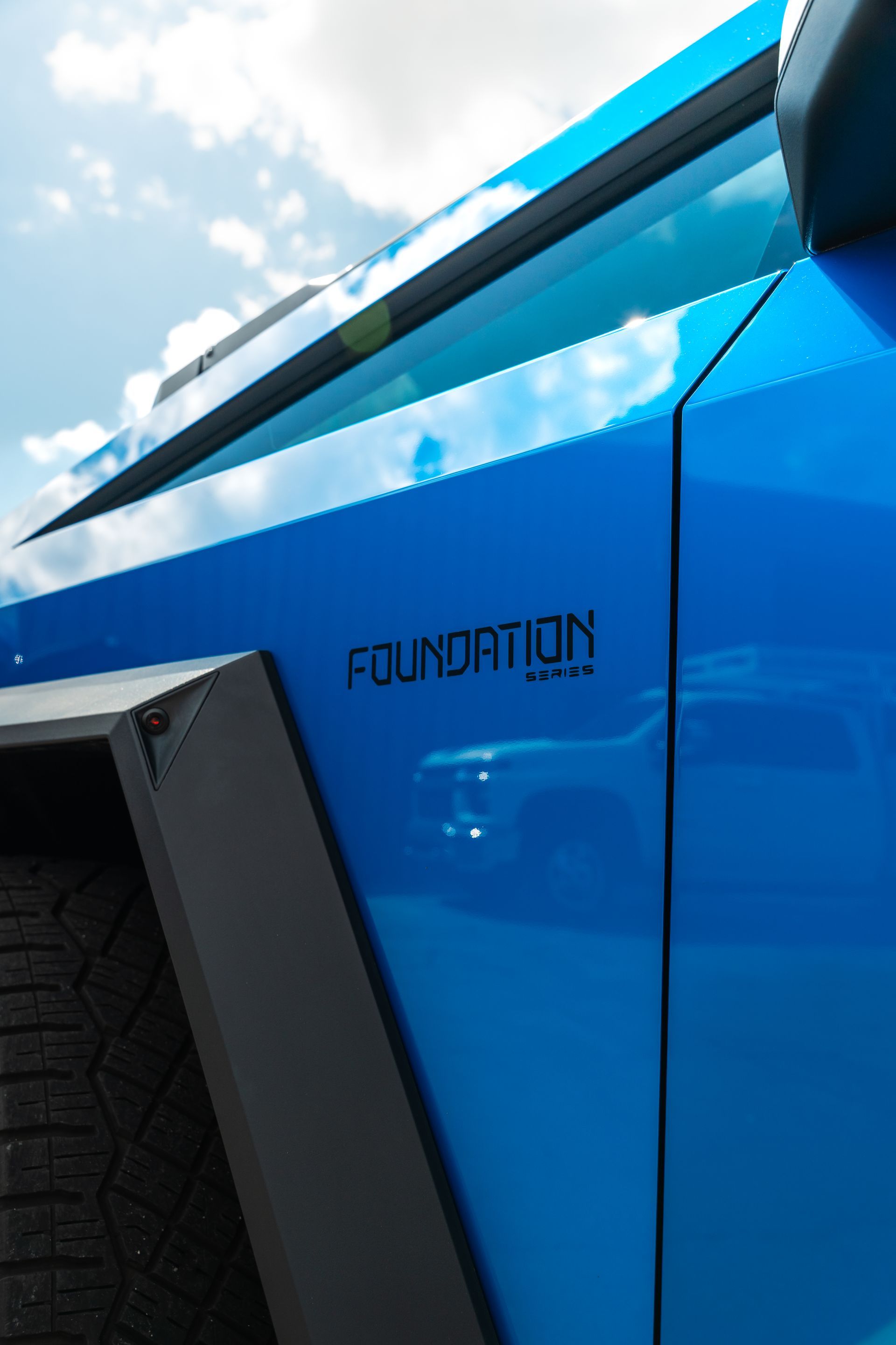 Blue off-road vehicle side panel with black fender and visible “FOUNDATION” text.