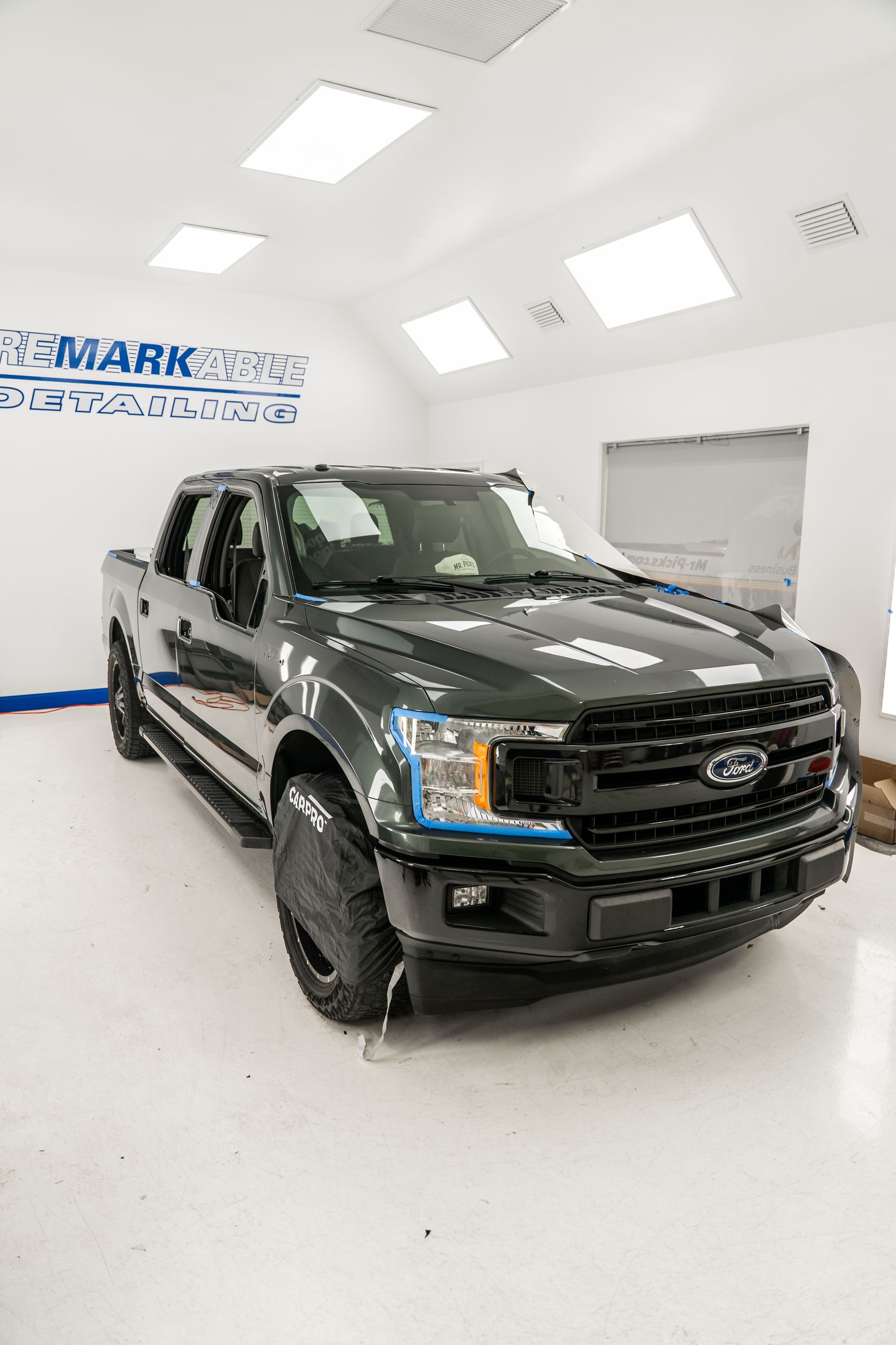 Black Ford pickup truck in a bright white showroom