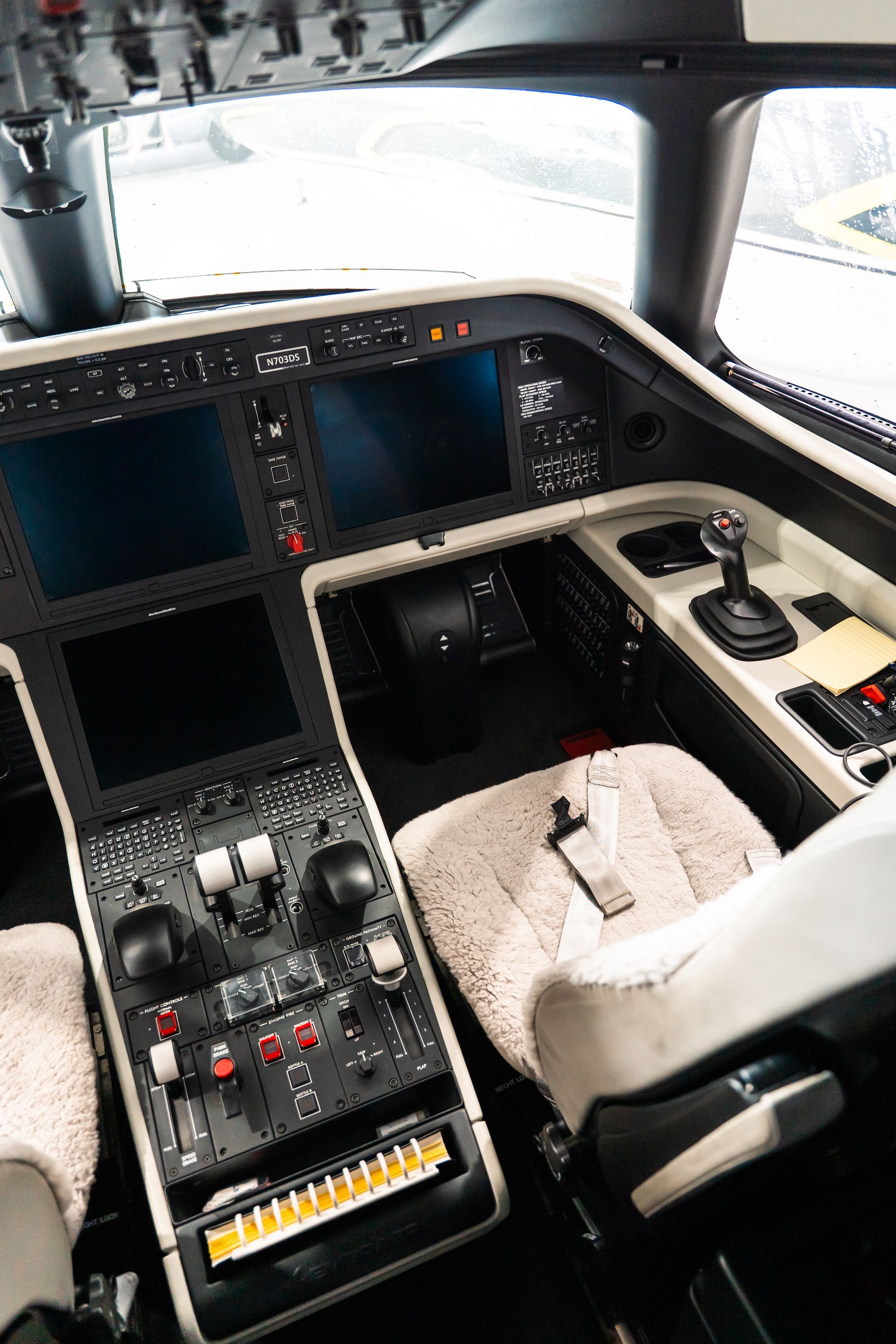 Airplane cockpit interior with instrument panels, pilot seats, and control yokes.