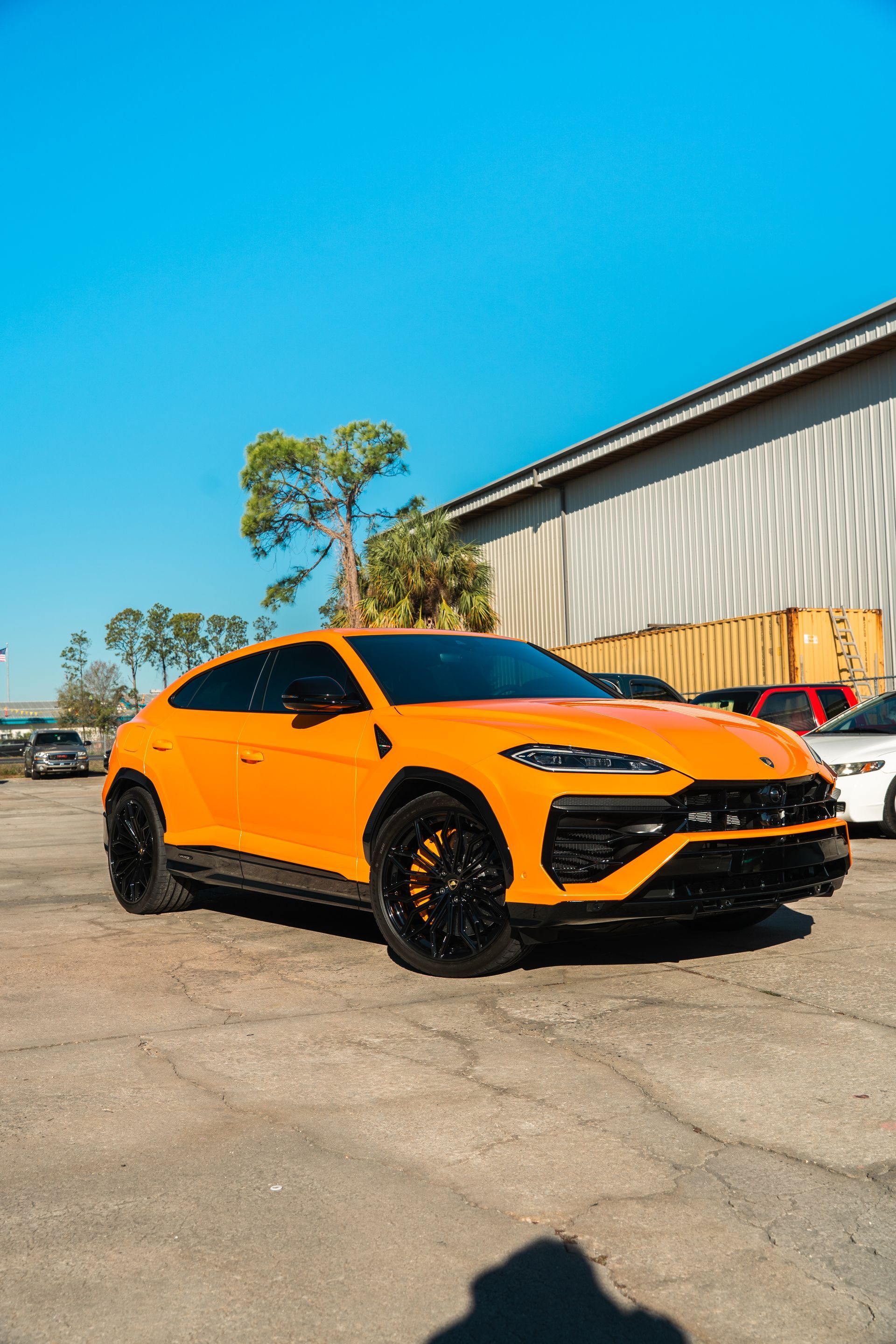 Orange sports SUV parked outside a warehouse on a sunny day