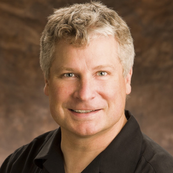 A man wearing a black shirt is smiling for the camera