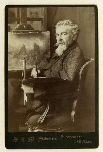 Sepia portret van een bebaarde man die naast een schilderij op een ezel zit en een penseel vasthoudt in een atelier.