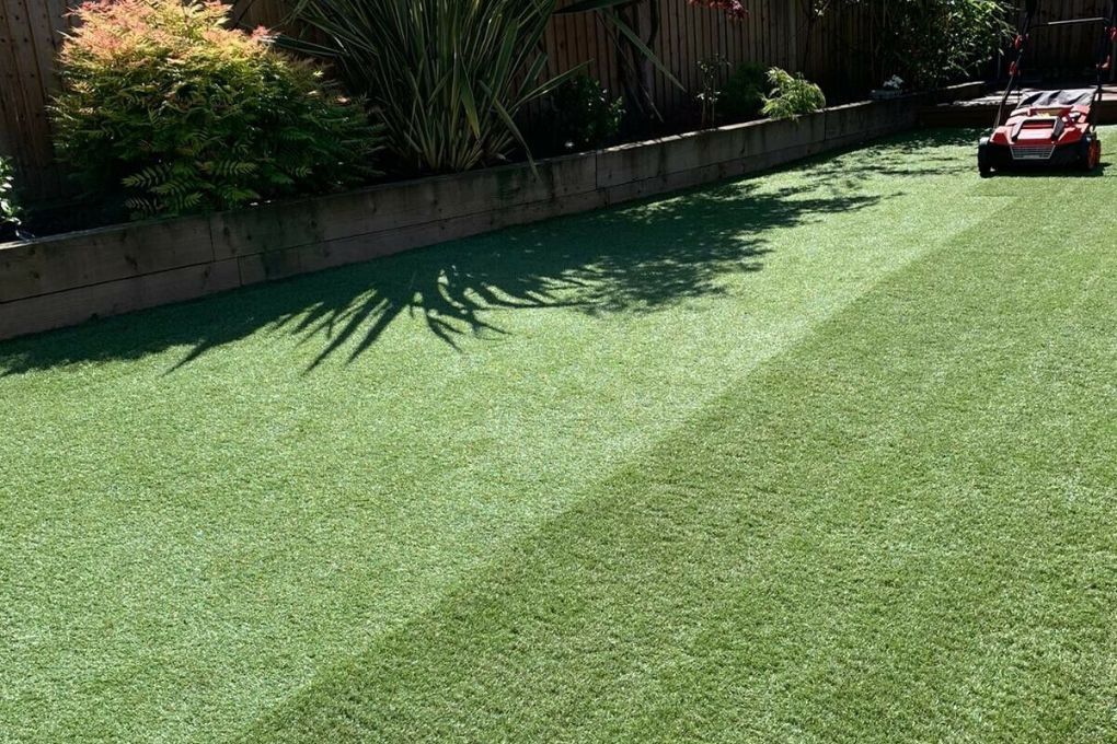 Artificial Grass Coventry part way through power brushing an artificial lawn as part of a maintenance service