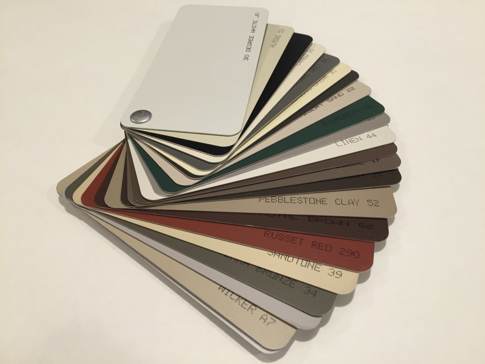 Fan of assorted paint or material swatches on a white surface