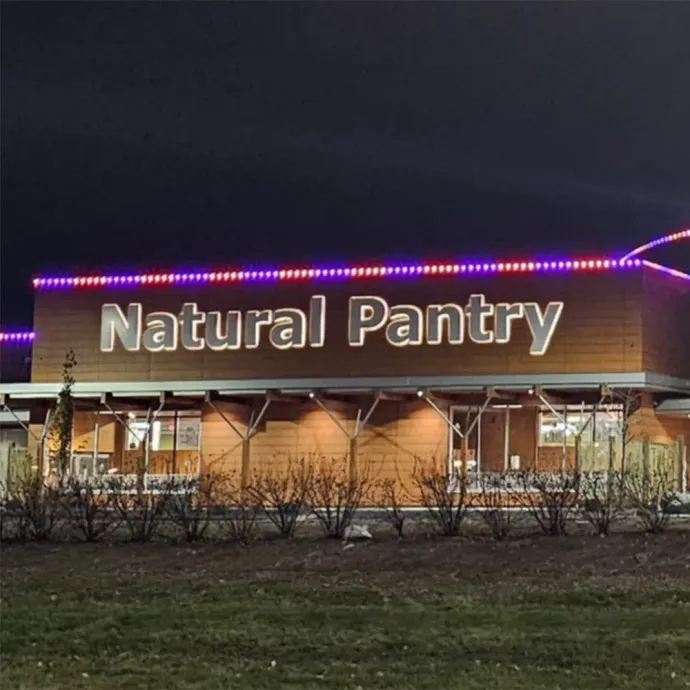 Natural Pantry storefront at night with purple roof lights and illuminated sign