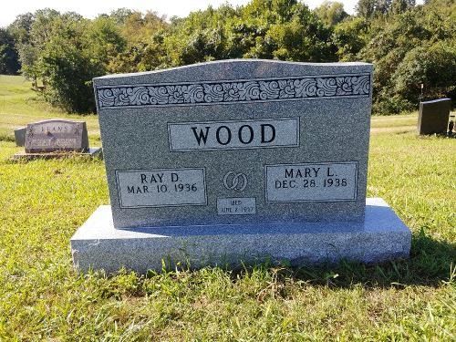 A grey granite grave marker in a cemetery engraved with the name 