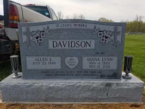 Gray granite headstone for the Davidson family, featuring two names and dates, set in a grassy cemetery.