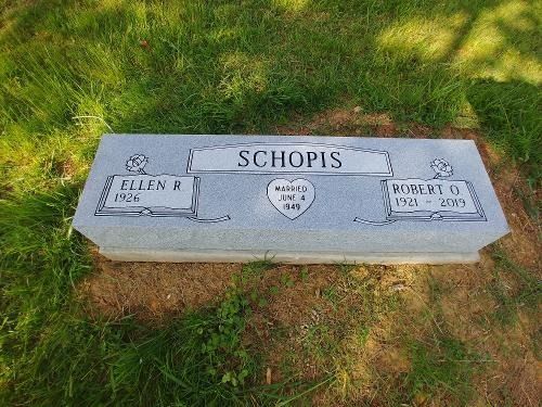 A rectangular gray granite gravestone for the Schopis family, inscribed with the names Ellen A. and Robert O., in grass.