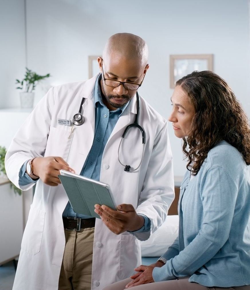 Doctor reviewing a chart with a seated patient in a clinic