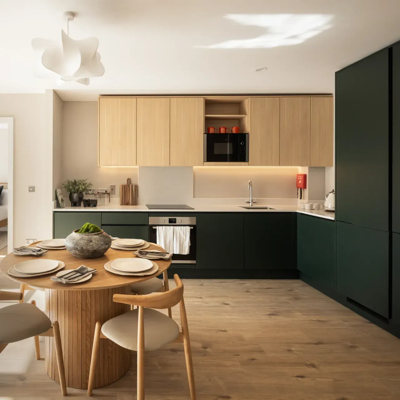 Modern kitchen and dining area with wood table, black cabinets, and light wood accents