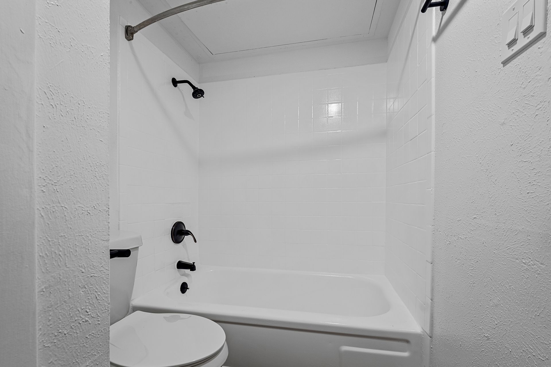 Photo showing a toilet next to a bathtub/shower combo