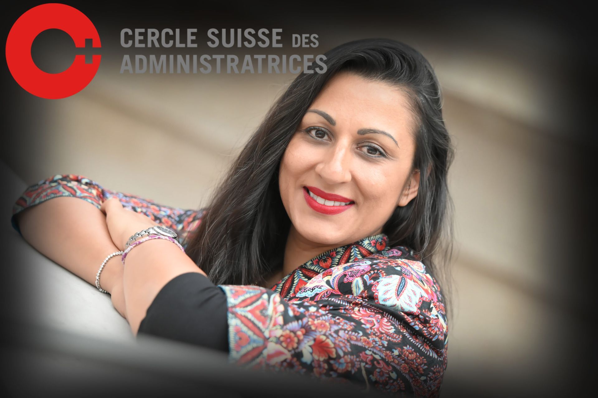 Femme souriante en chemisier à motifs avec le logo CERCLE SUISSE DES ADMINISTRATIVES