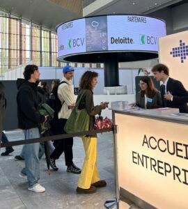 Des personnes font la queue à la réception d'une entreprise dans un hall moderne arborant les enseignes Deloitte et BCV.