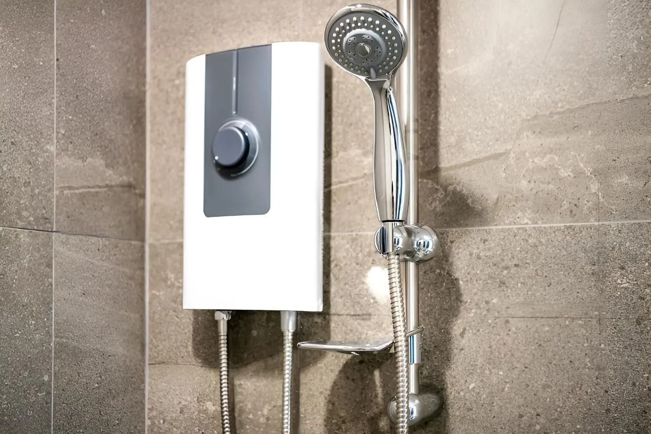 Bathroom shower with a chrome handheld showerhead and a white wall-mounted control panel against beige tile.