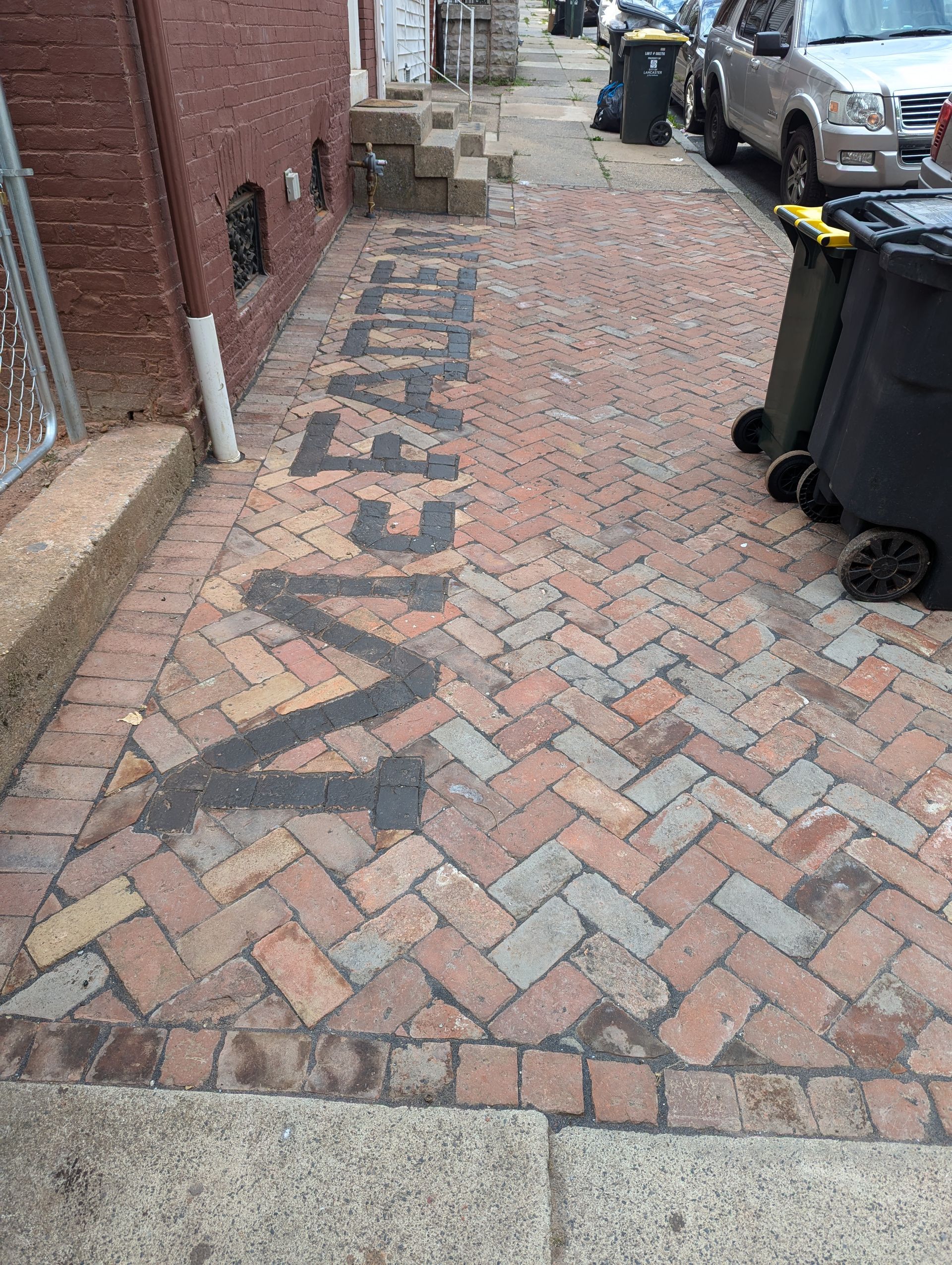 Brick walkway between a red brick building.