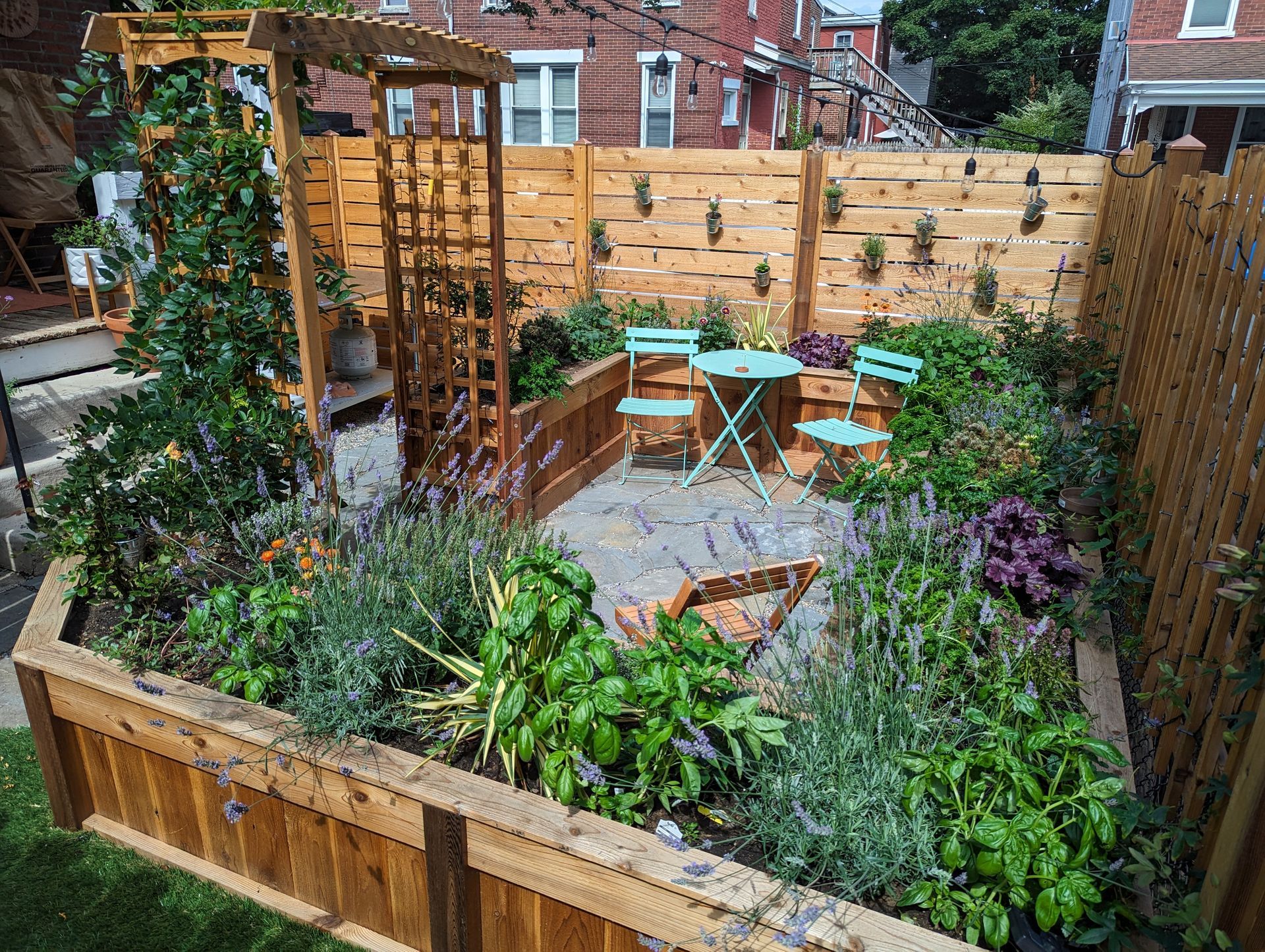 Brown house with a paved walkway, black mulch, and landscaping.