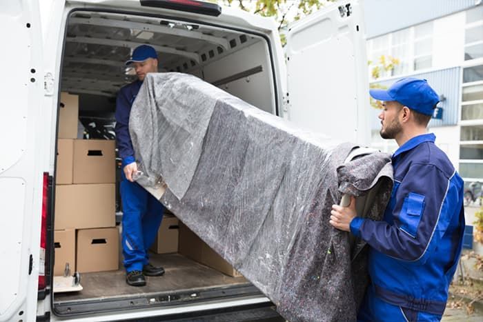 Two Men Loading a Couch Into the Back of A Van — Town & Country Removals In Wauchope, NSW