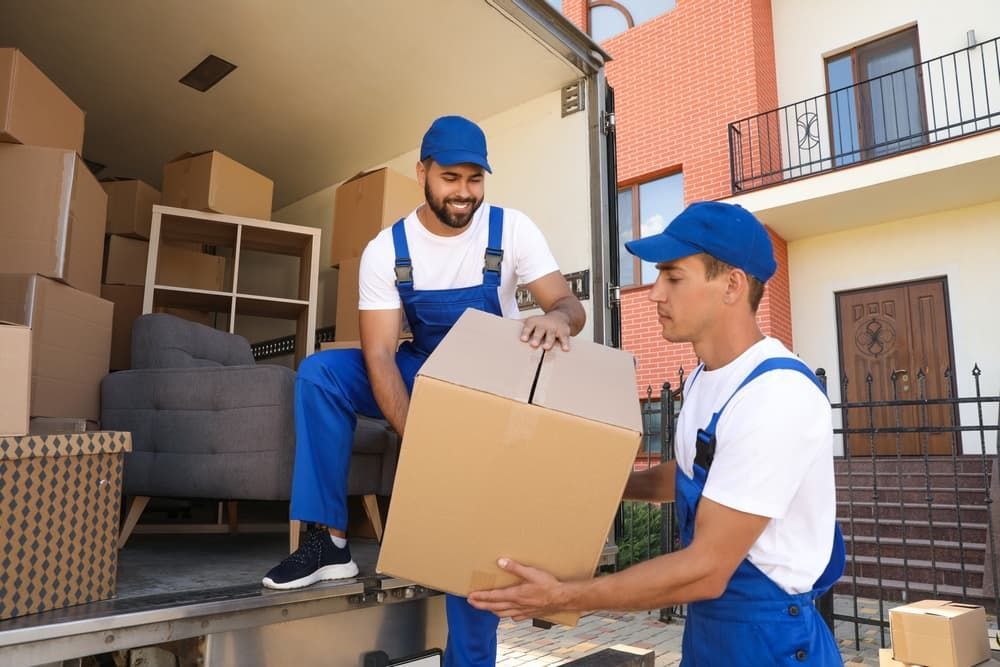 Two Men Carrying Boxes out Of a Moving Truck — Town & Country Removals In Wauchope, NSW