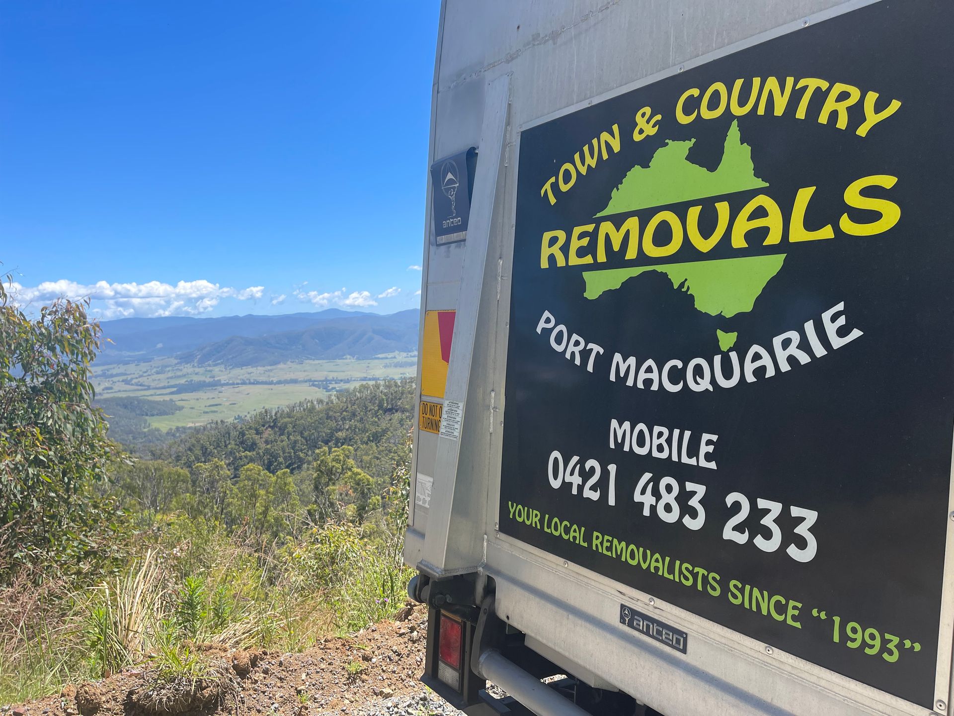 A Moving Truck Parked in a Hill with The View of the Land — Town & Country Removals In Thrumster, NSW