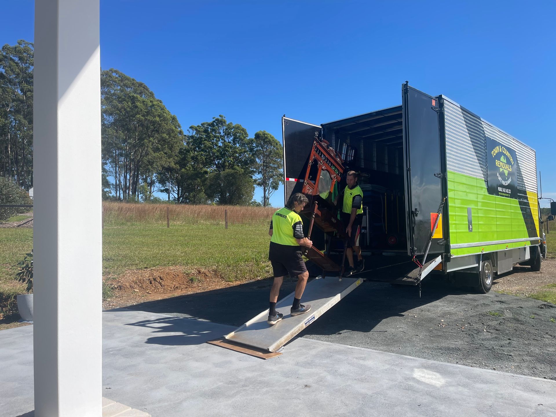 Two Men Unloading  Into a Van — Town & Country Removals In Thrumster, NSW