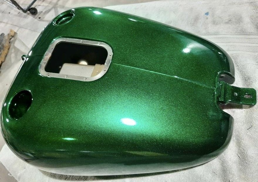 Green metallic motorcycle gas tank, freshly painted.