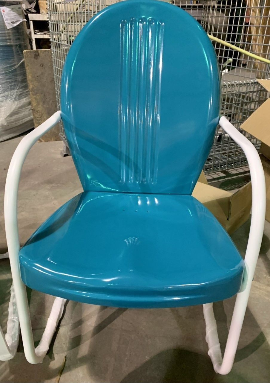 Teal metal chair with white armrests, indoors.