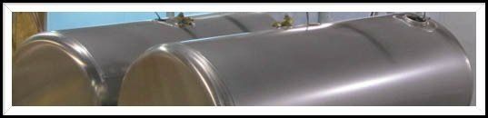 Two large, shiny, cylindrical metal tanks. They are horizontal and appear to be outdoors.