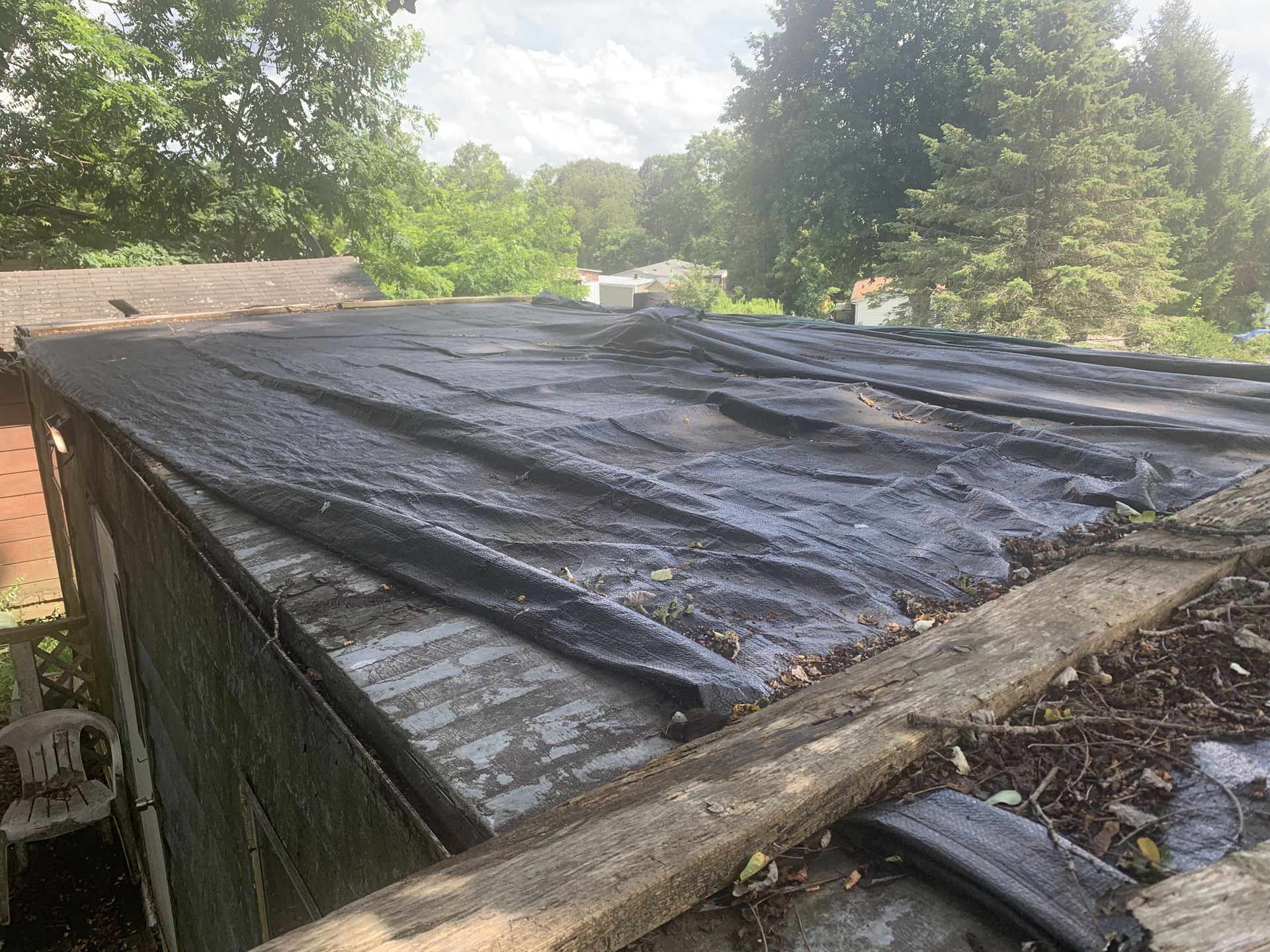 Flat roof hit by a storm and being repaired with 24/7 emergency services