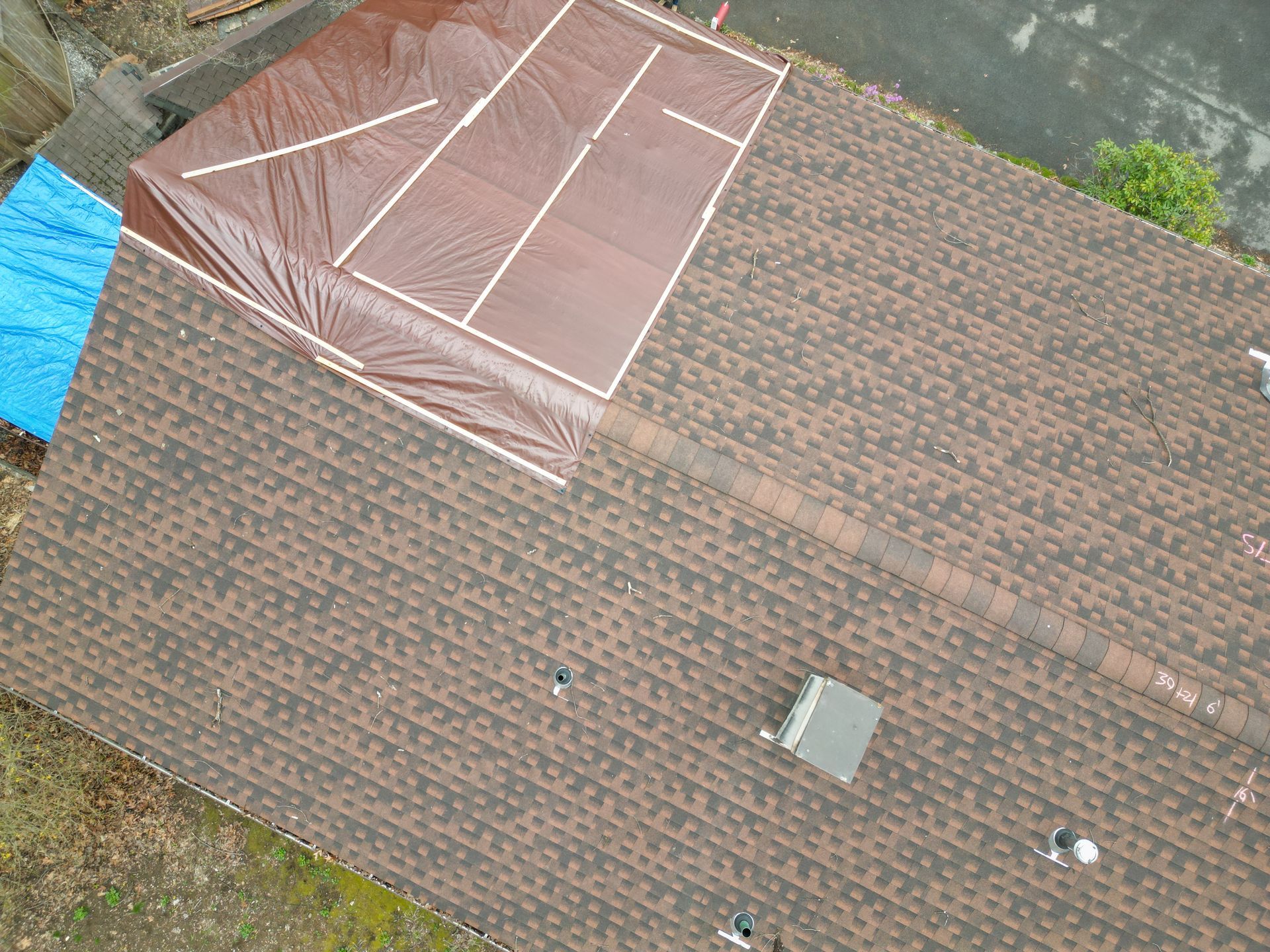 An aerial view of roof repair on damaged roof