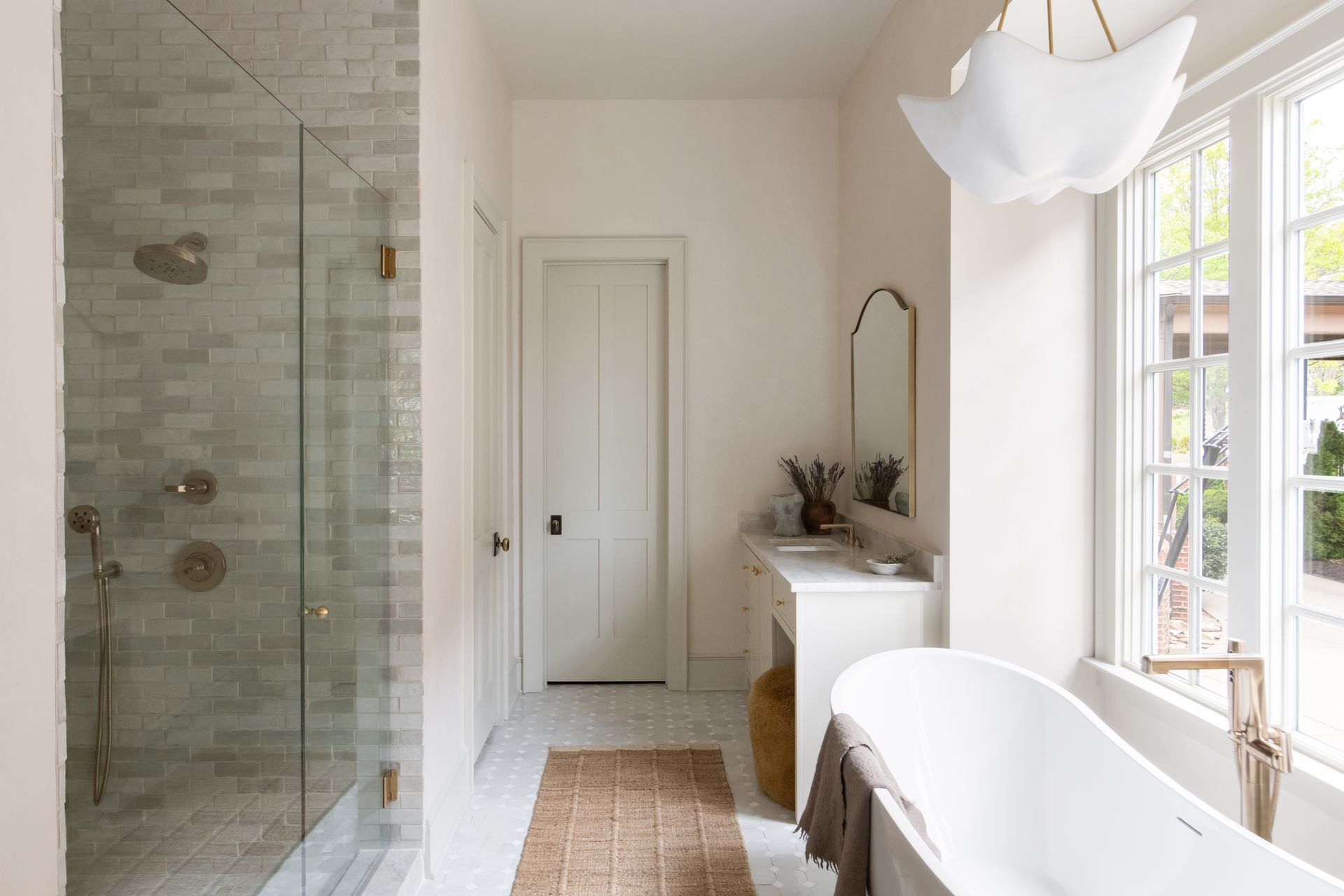 Luxury European inspired bathroom designed by nashville interior designer featuring taj mahal quartzite and zellige tile