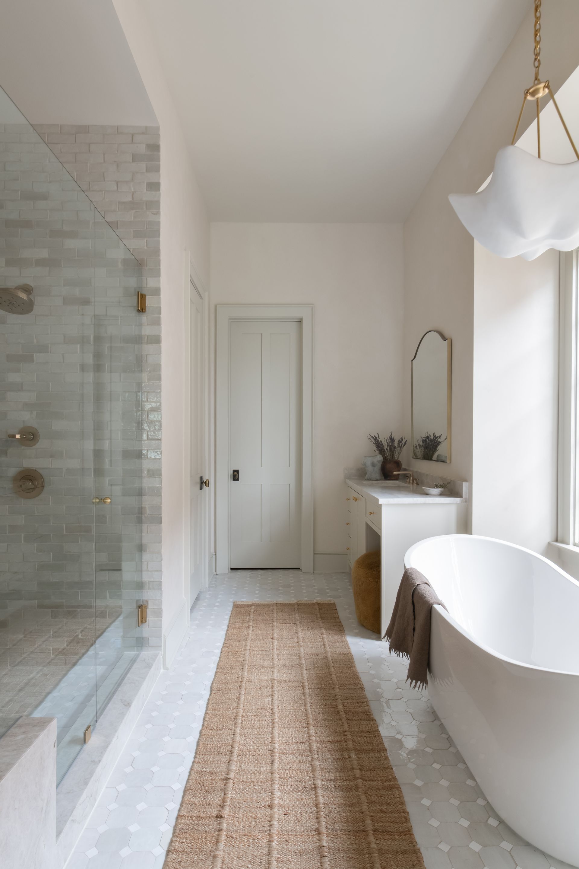 Luxury European inspired bathroom designed by nashville interior designer featuring taj mahal quartzite and zellige tile