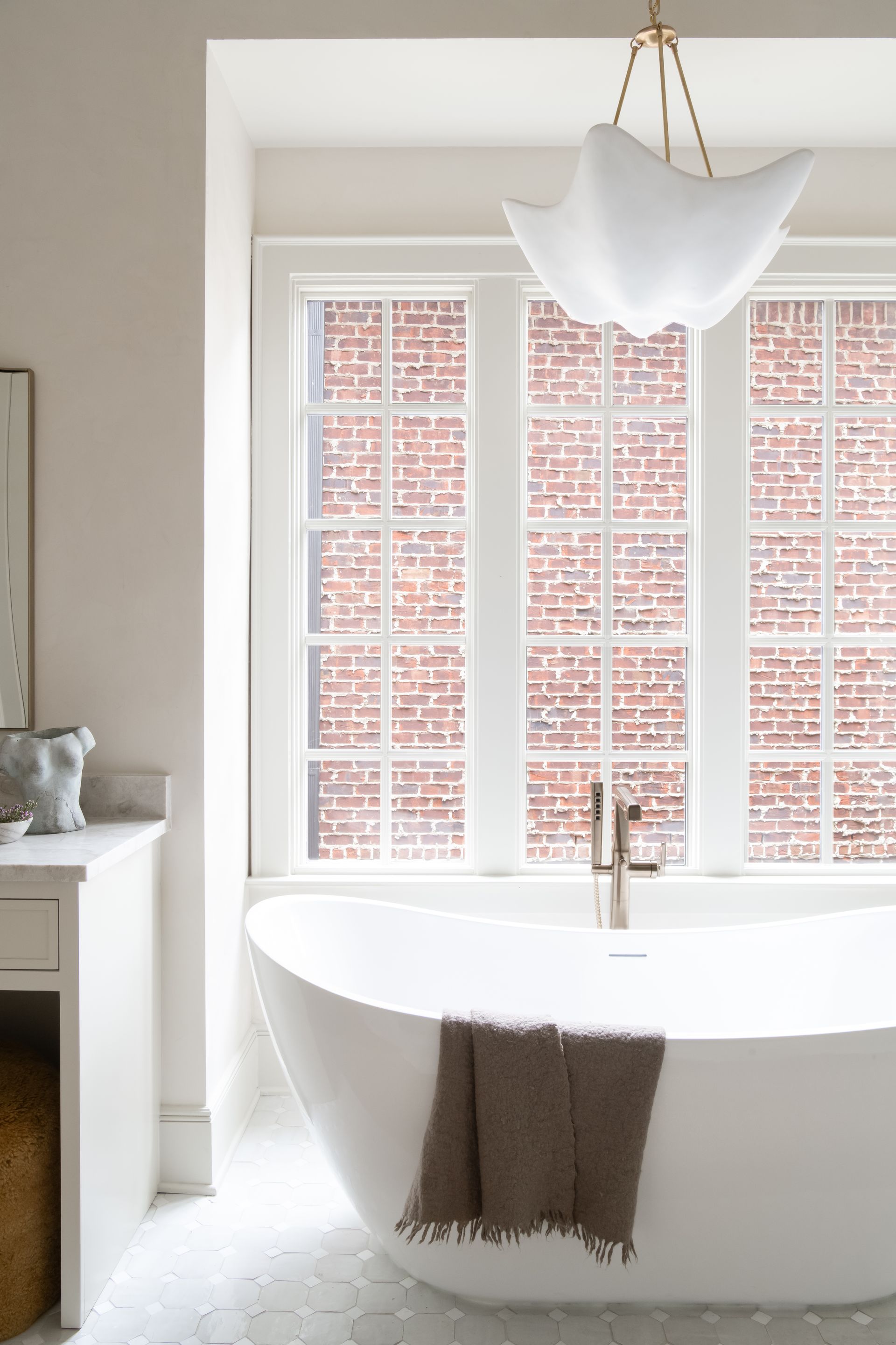 Luxury European inspired bathroom designed by nashville interior designer featuring taj mahal quartzite and zellige tile