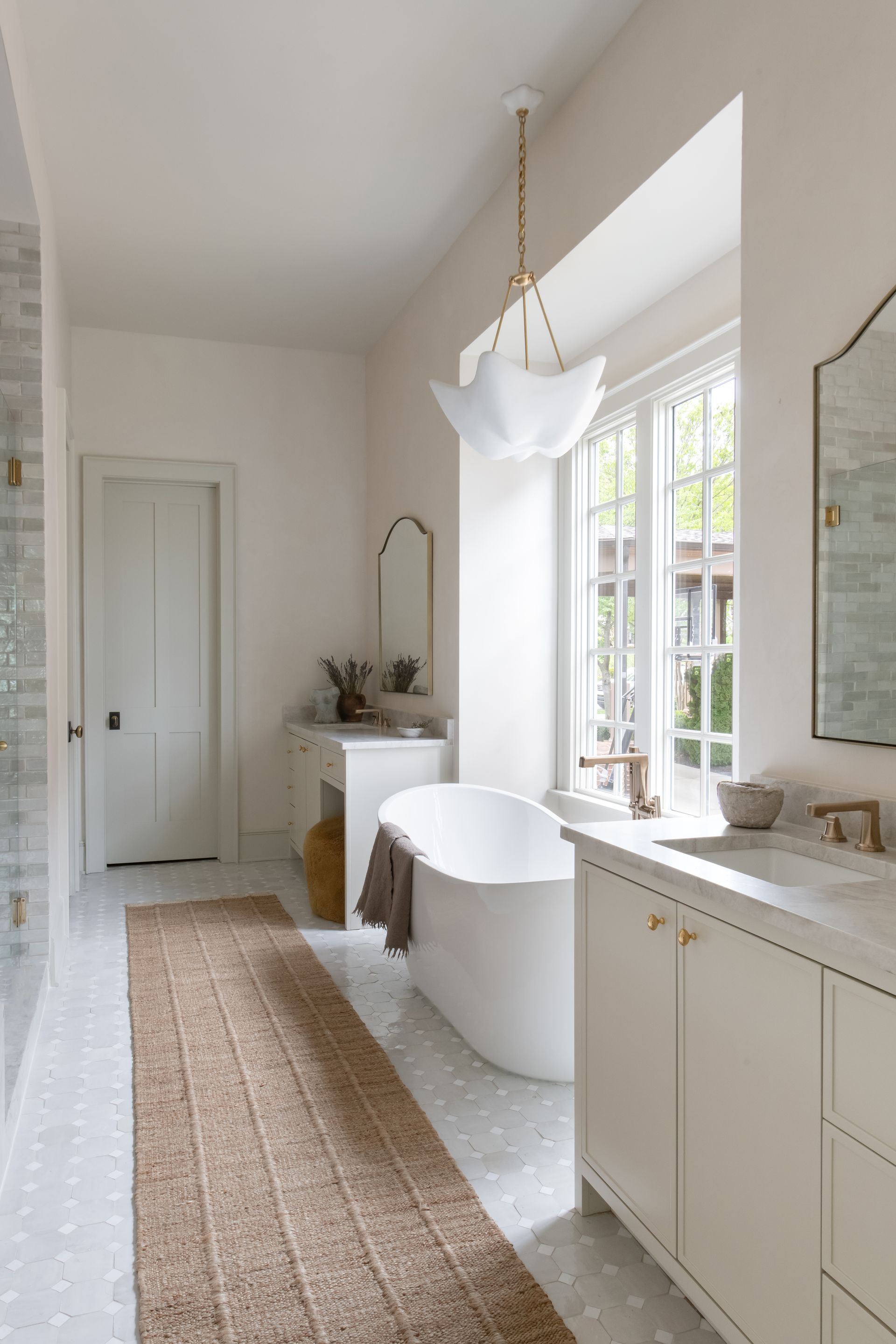 Luxury European inspired bathroom designed by nashville interior designer featuring taj mahal quartzite and zellige tile