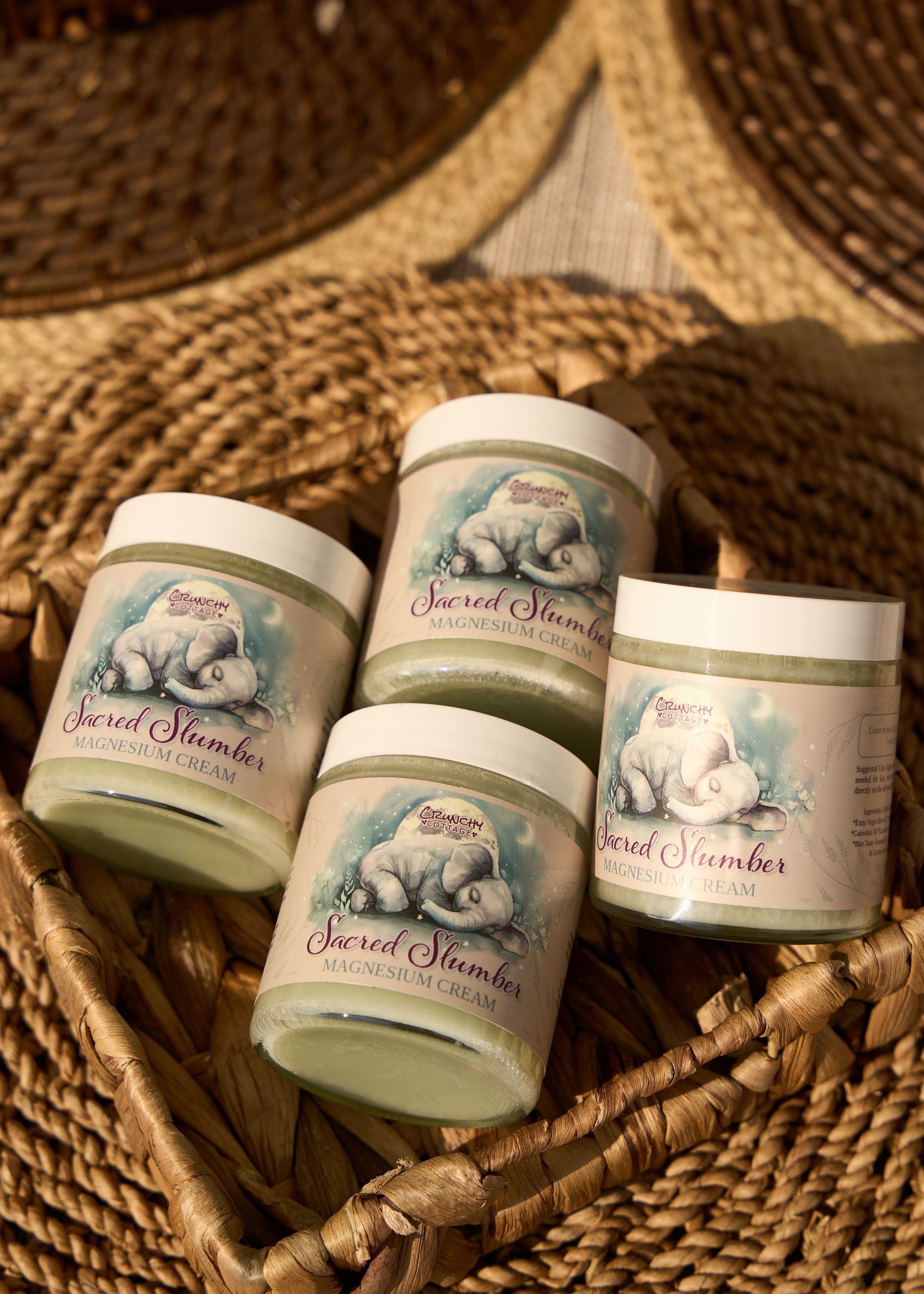 Four pastel candle jars with floral labels arranged in a woven basket at the Loomis Community Farmers Market