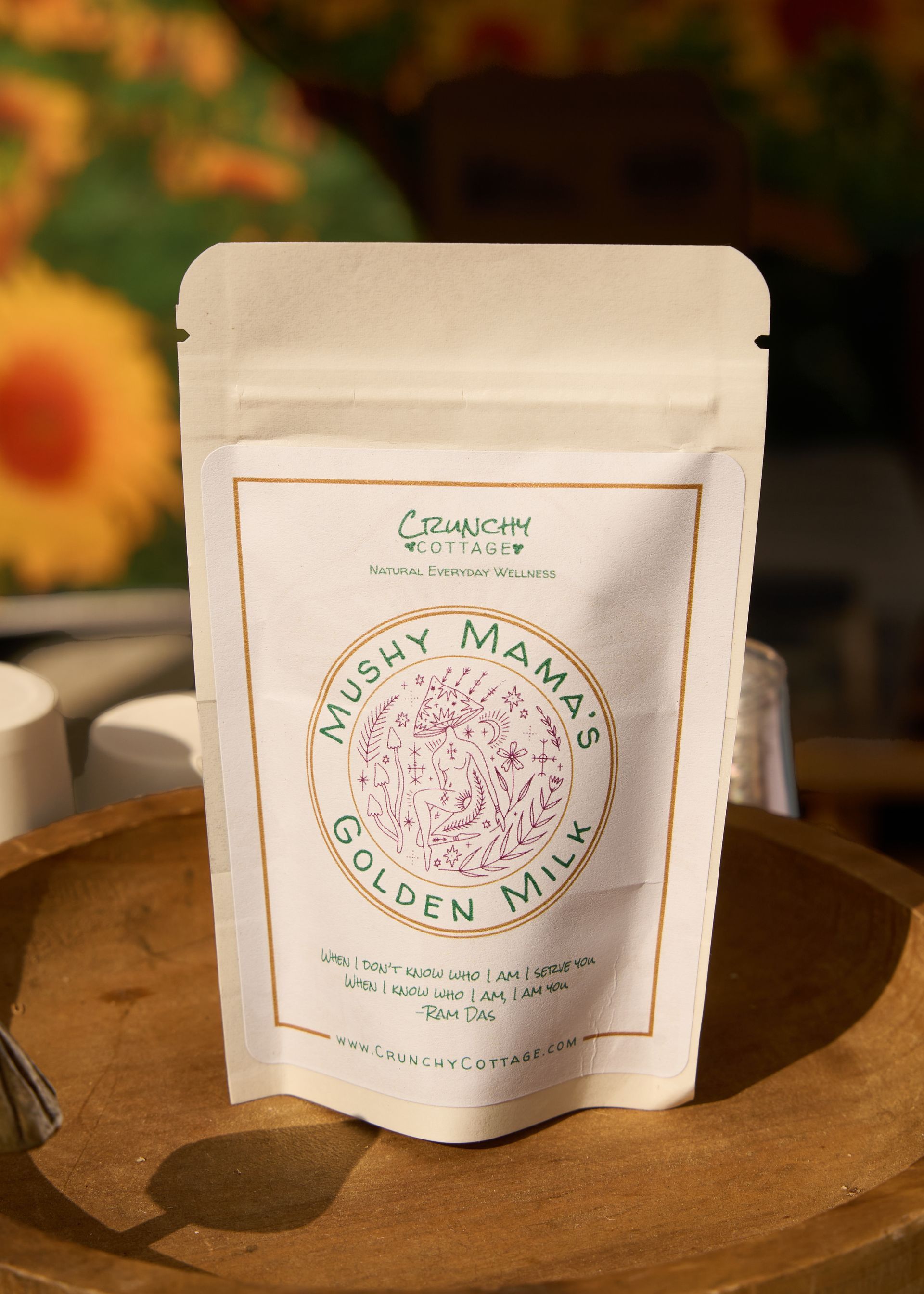 White stand-up pouch of Golden Milk powder displayed on a wooden tray with floral decor at the Loomis Community Farmers Market