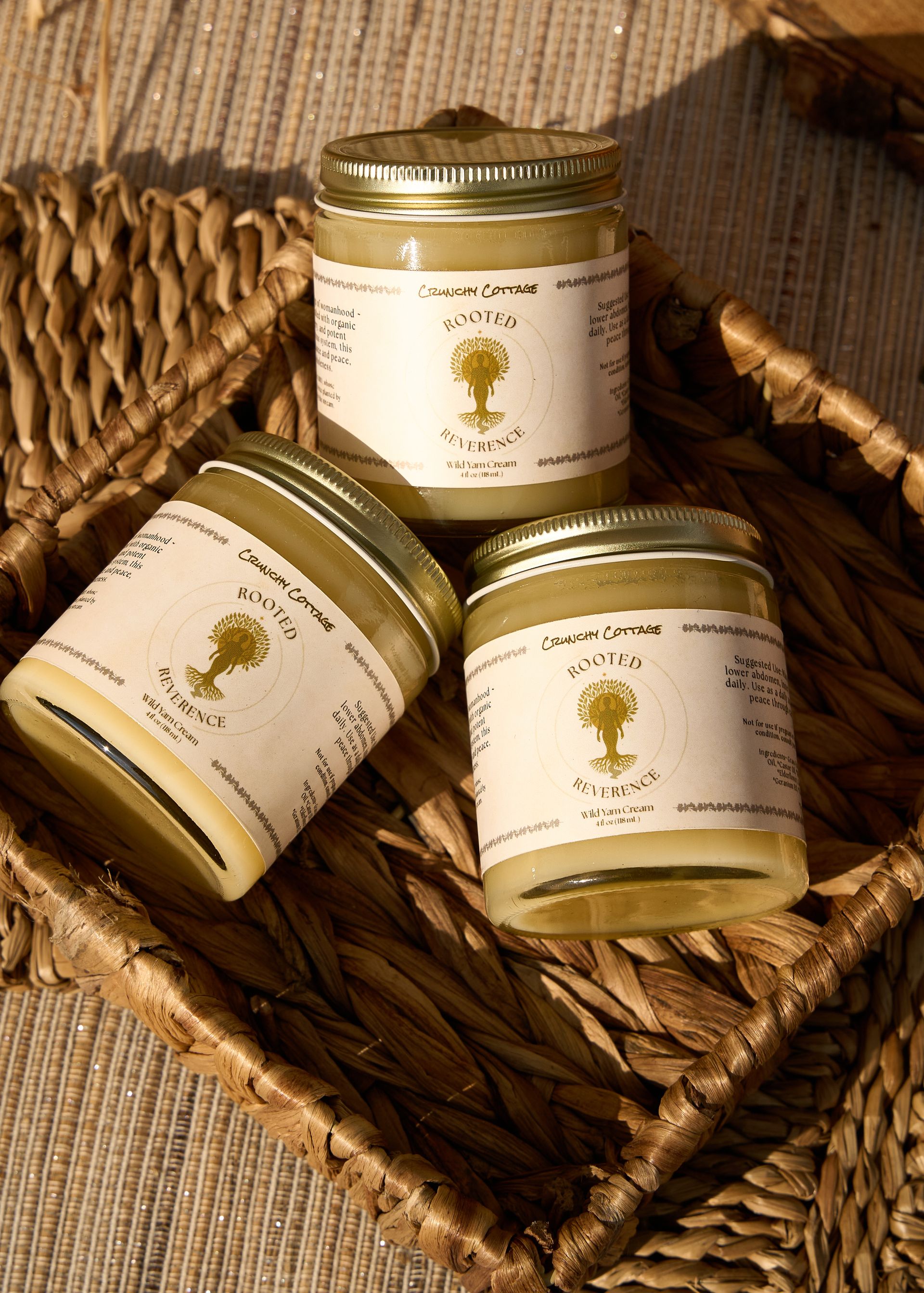 Three small artisan jars with gold lids arranged in a wicker basket on a rustic wooden surface at the Loomis Community Farmers Market