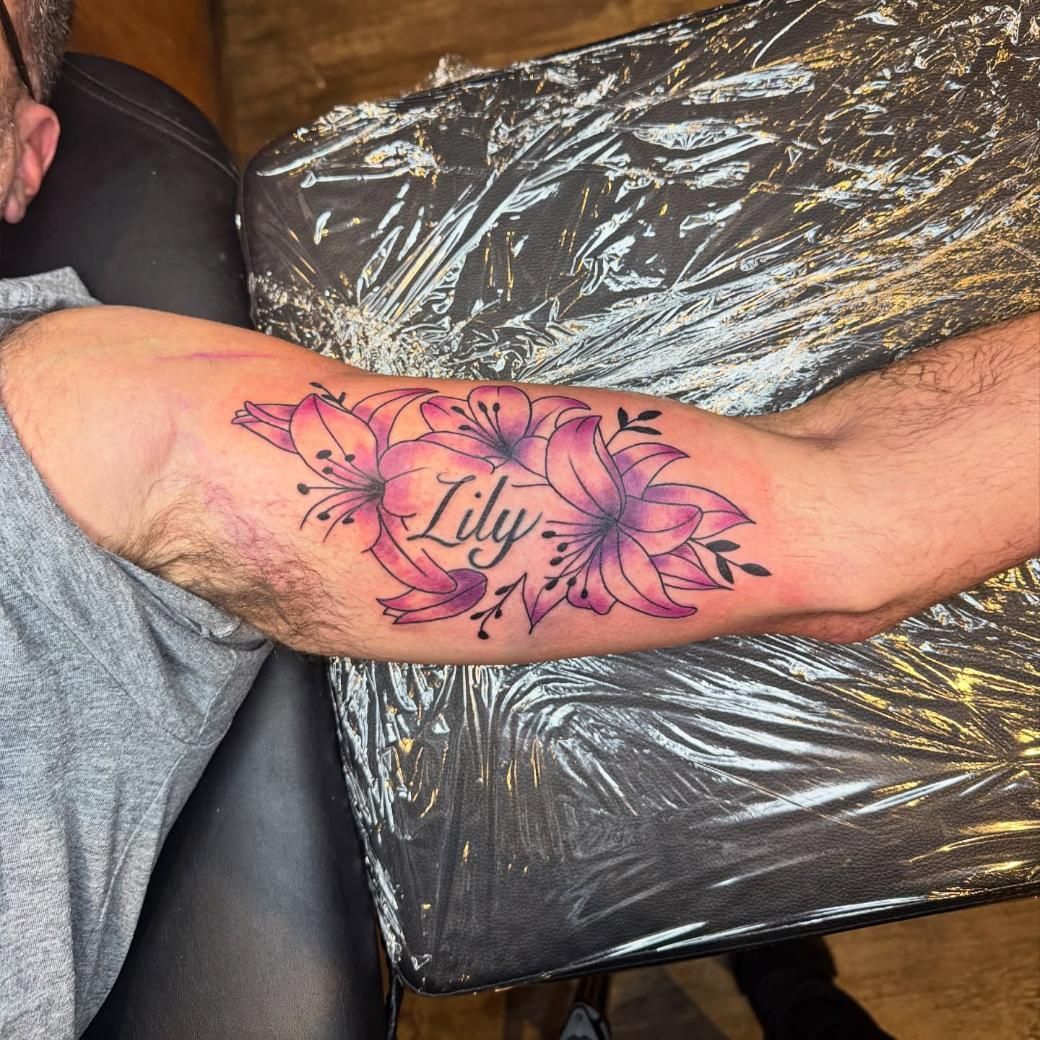 Tattoo of purple lilies and the name 