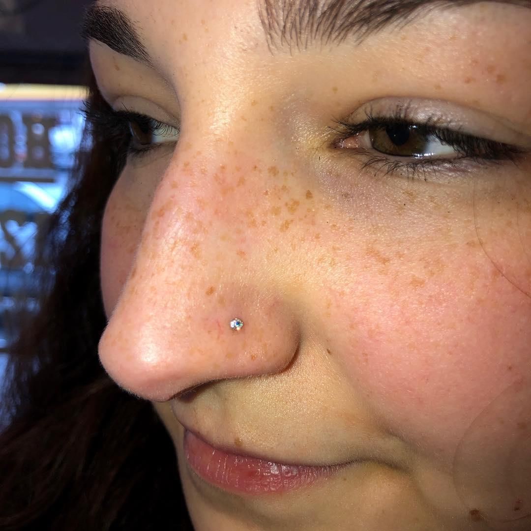 Close-up of a person's face with a nose piercing. 